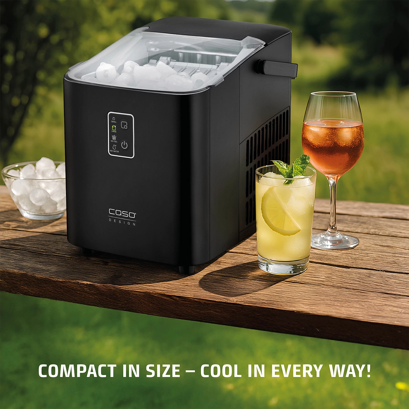 Ice maker with drinks on a wooden table outdoors. Minimal space requirement but cool.