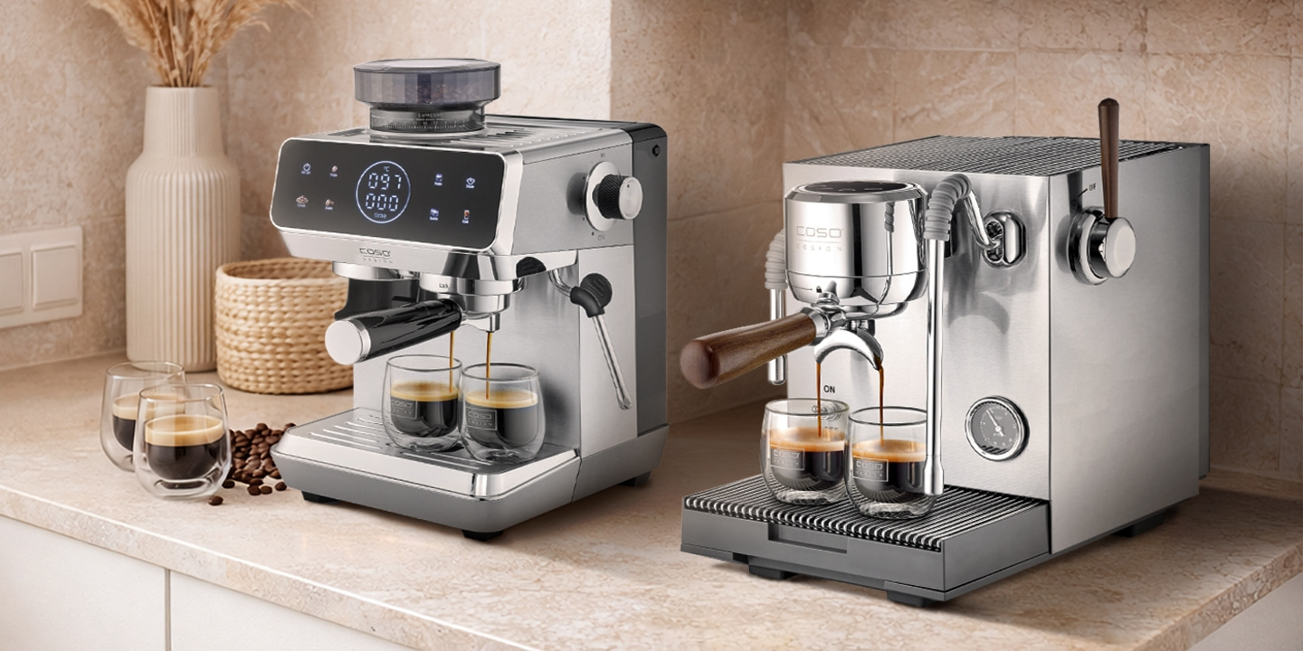 Two espresso machines brewing coffee into glasses on a kitchen countertop.