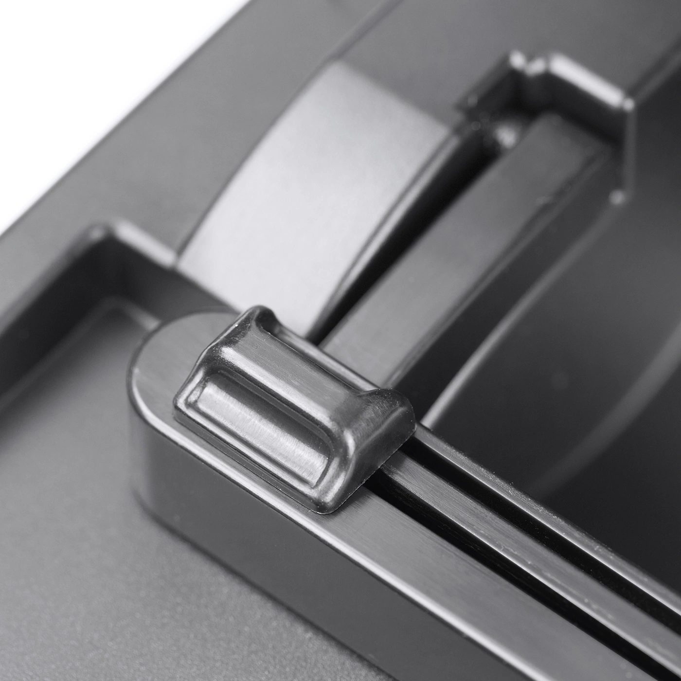 Close-up of a metal lever attached to a gray surface, with a shiny finish.