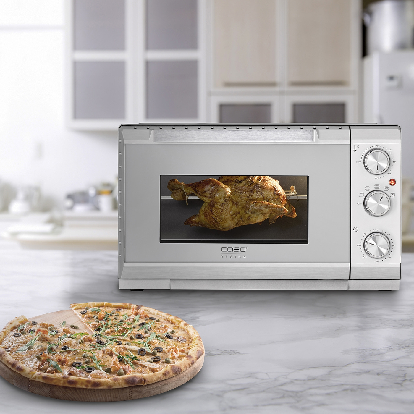 Ofen mit Hähnchen und Pizza auf einem Holzteller auf einer Marmoroberfläche