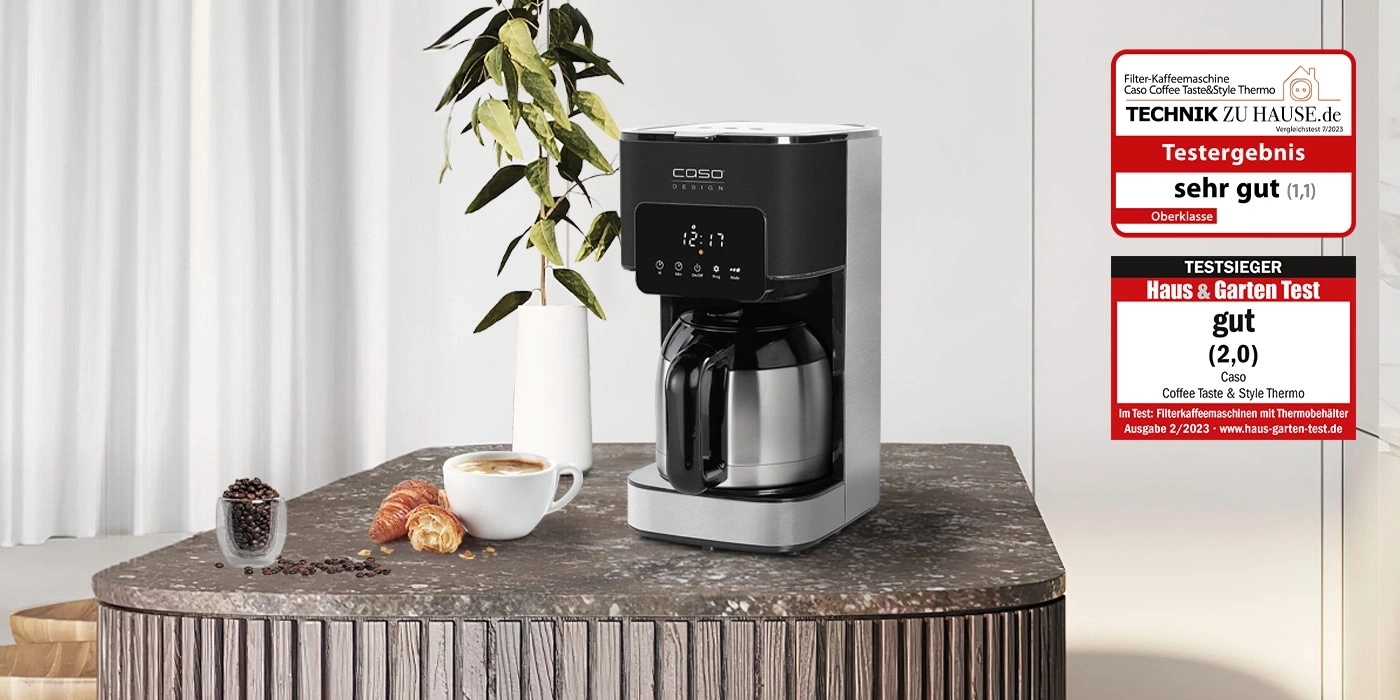 Kaffeemaschine mit Testergebnissen und Zubehör auf einem Tisch