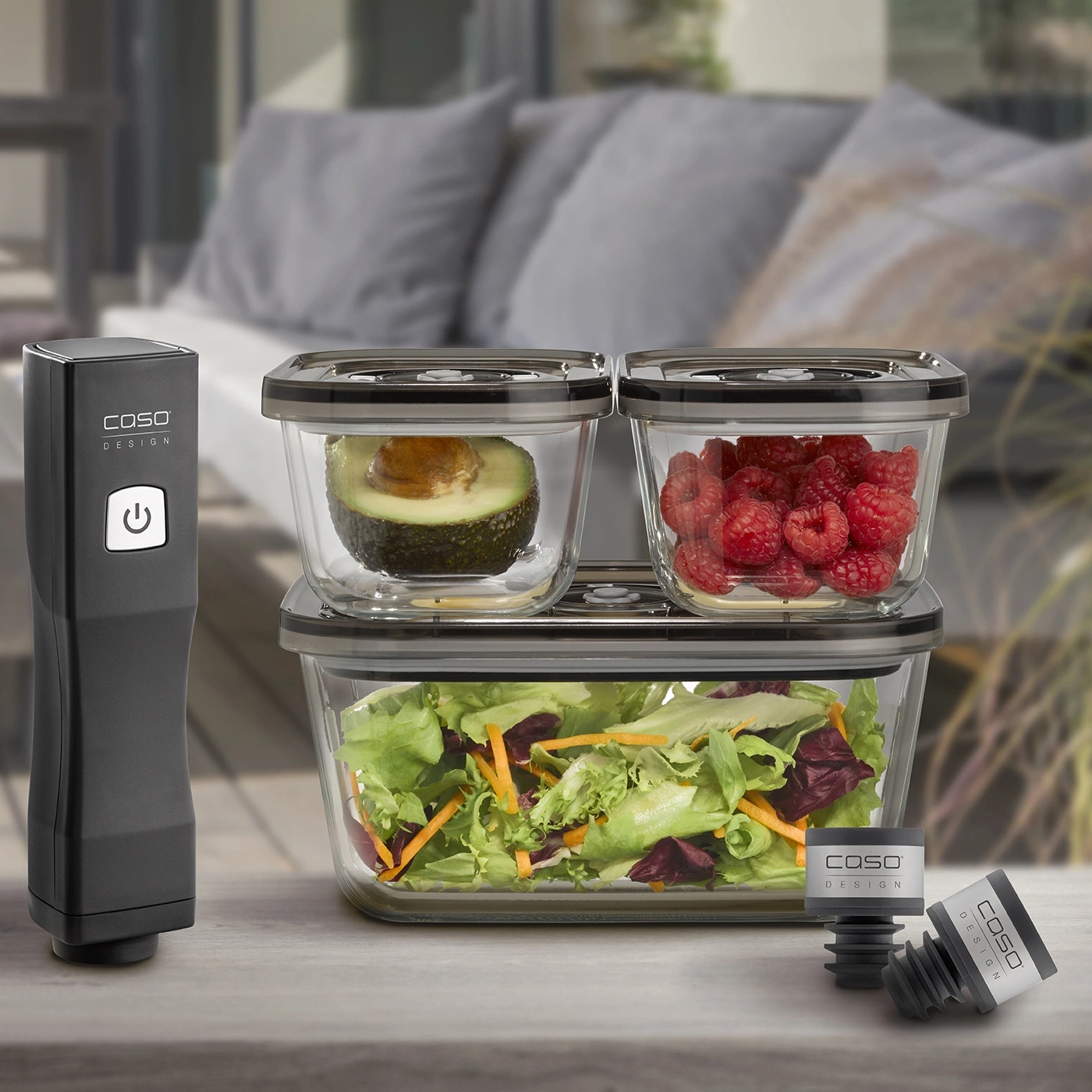 Vacuum sealer with containers, avocado, raspberries and salad on the table.