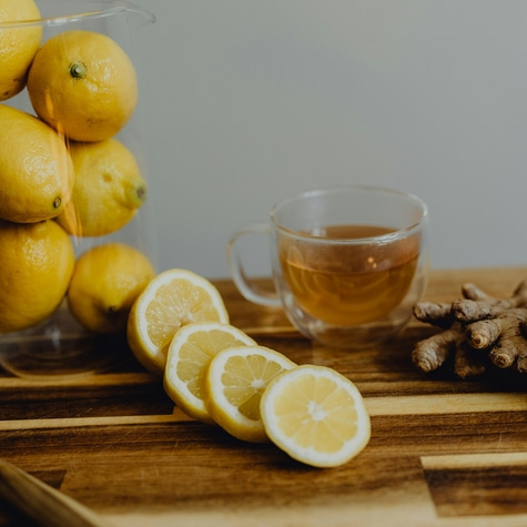 Lemon slices, tea, and ginger on a wooden board. Healthy drink.