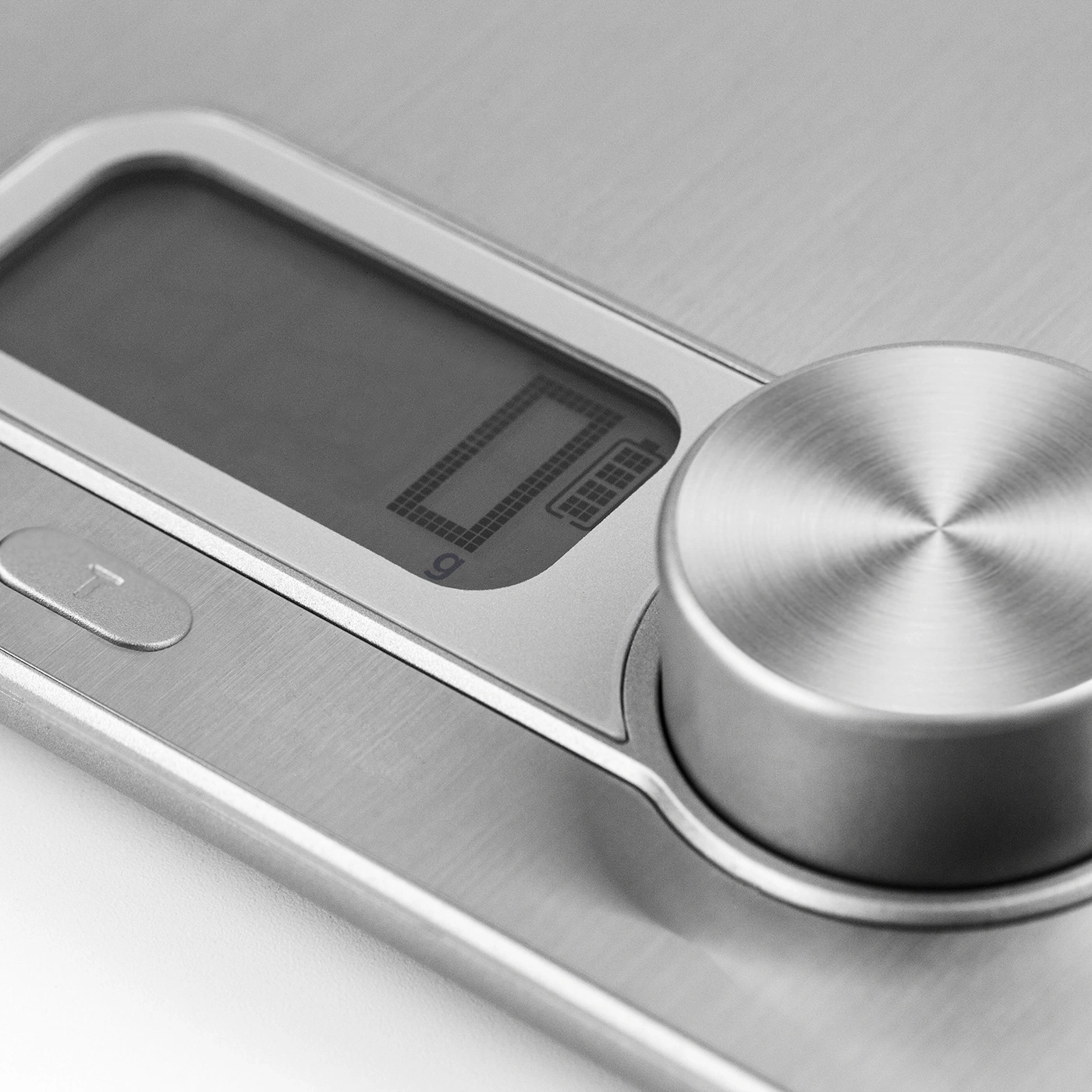 Close-up of a kitchen scale with digital display and metal dial, showing zero