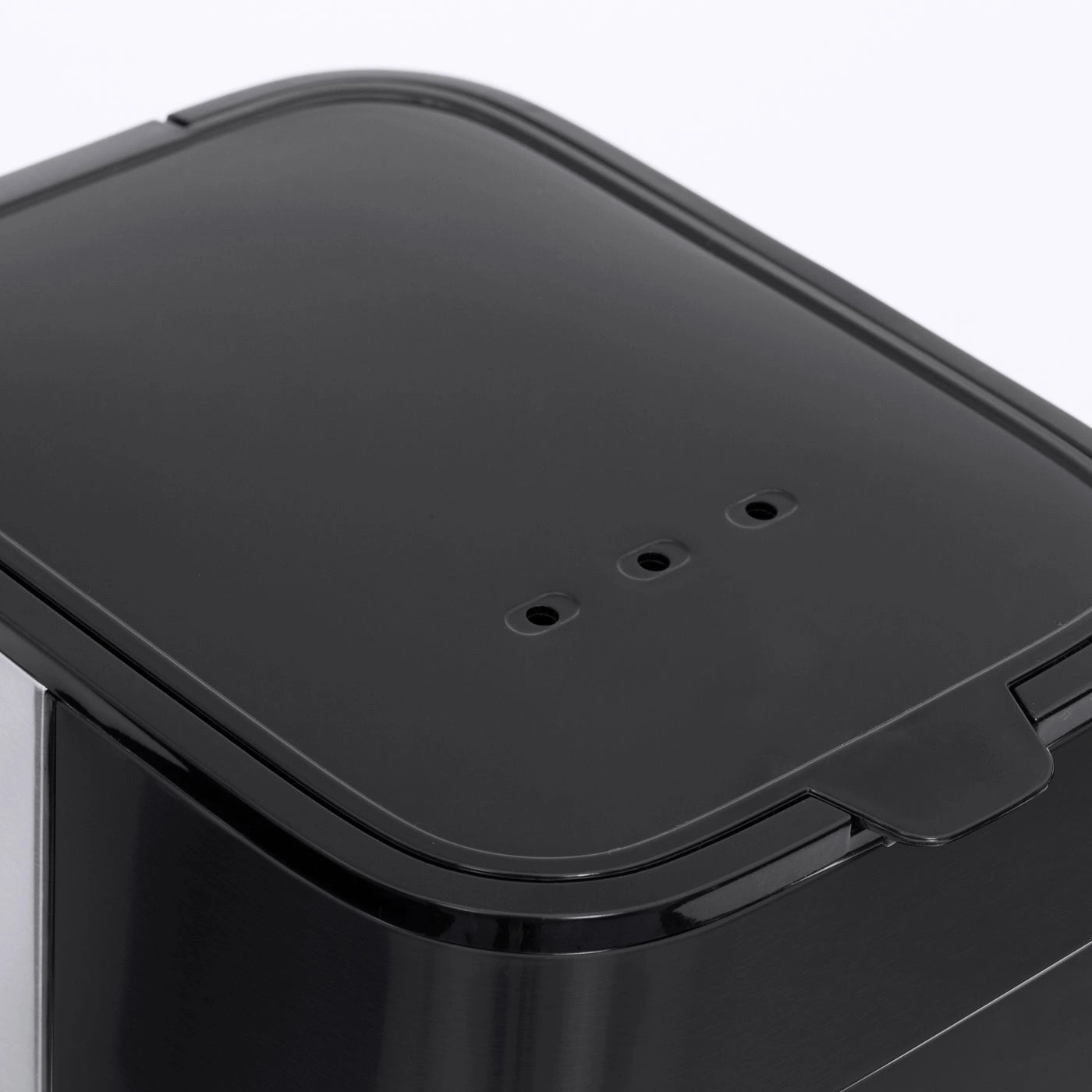 Black lid with holes and handle, close-up, detail shot, shiny surface