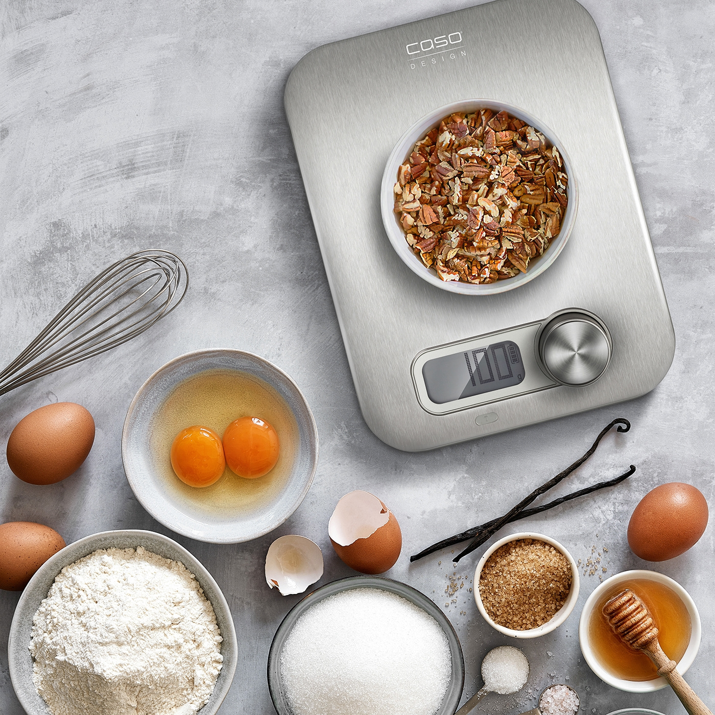 Baking ingredients on a scale, eggs, flour, sugar, honey, vanilla beans, nuts