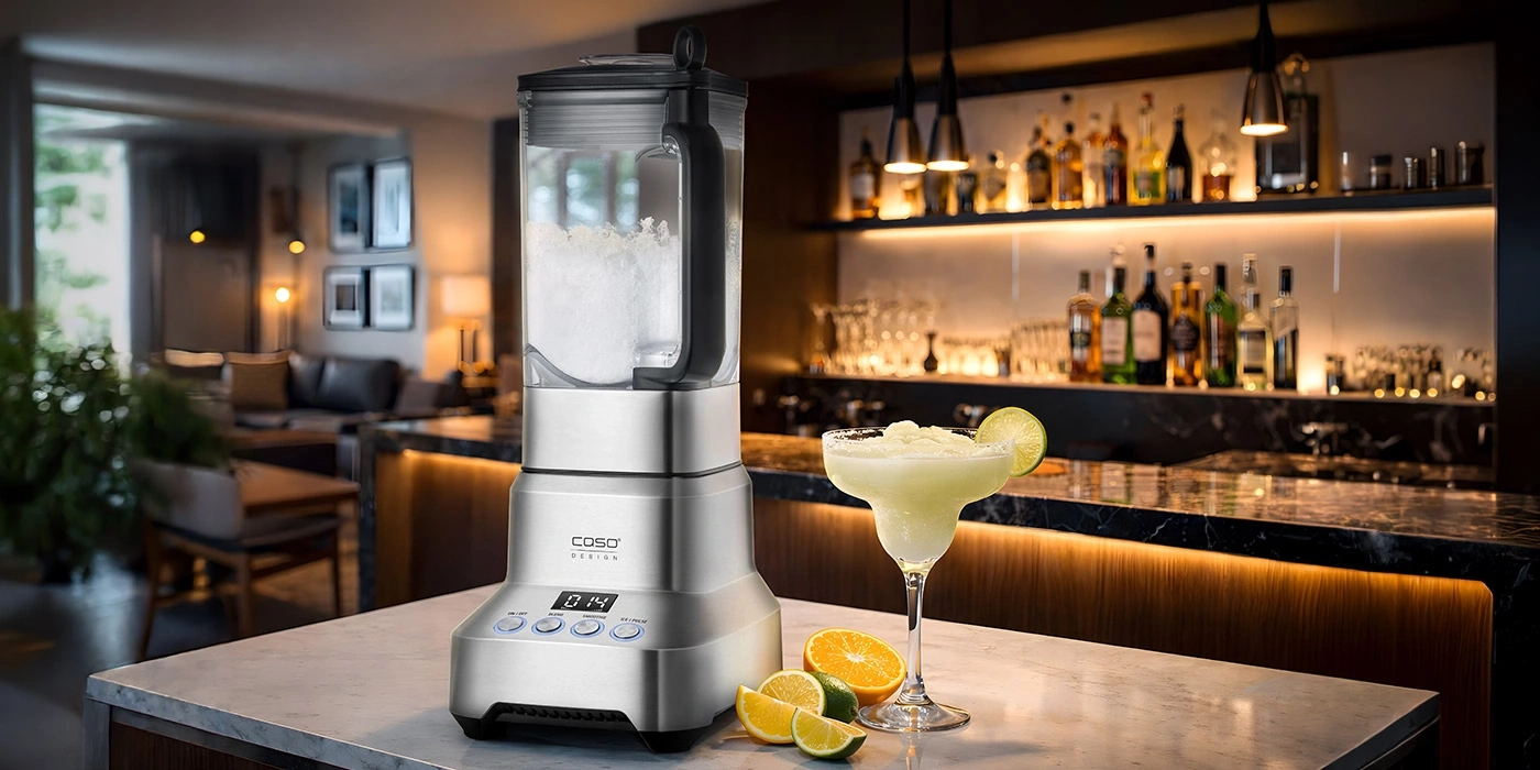A blender sits on a marble countertop with fruit and a margarita cocktail.