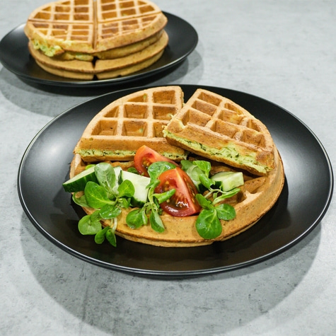 Waffles with salad and tomatoes on a black plate, delicious and tasty