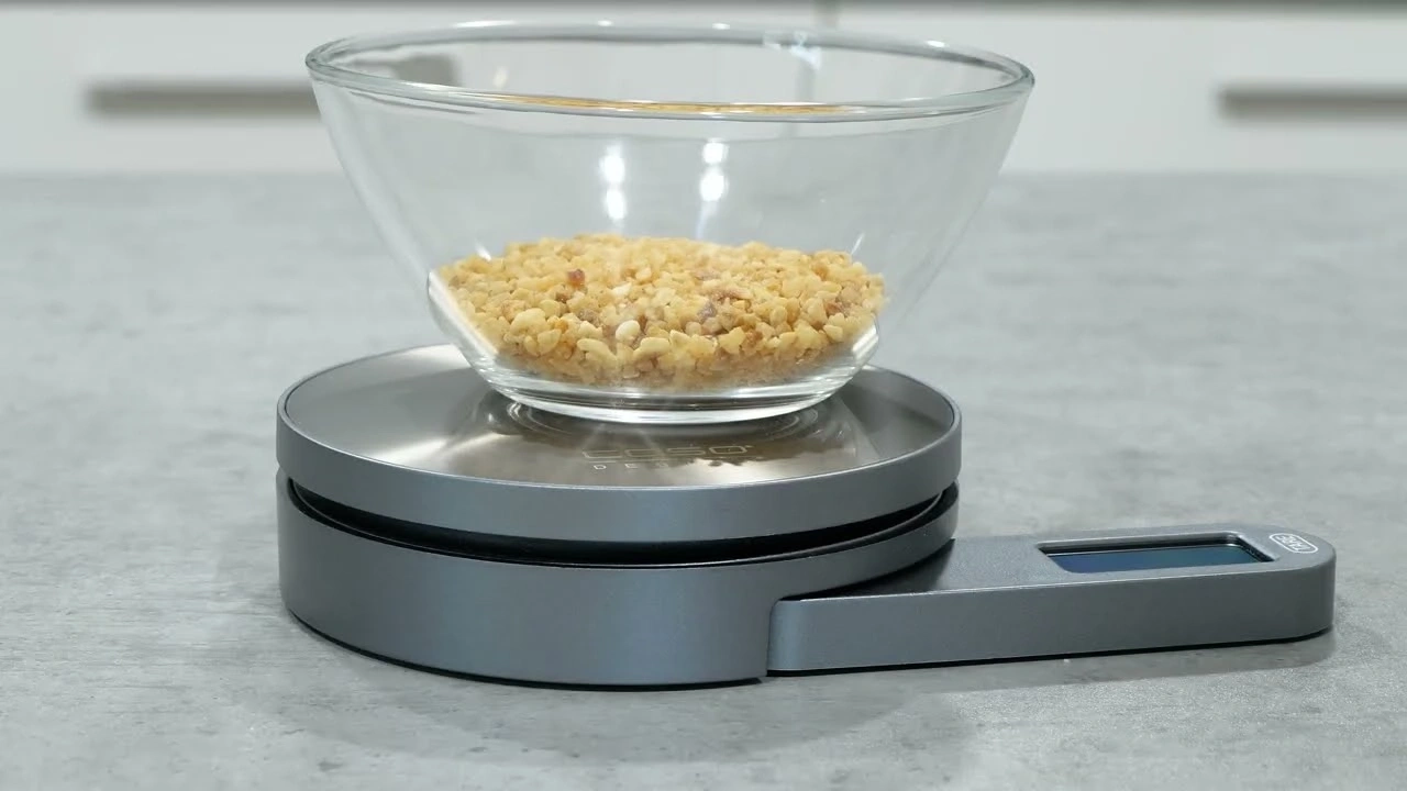 Eine Schüssel mit gehackten Nüssen auf einer digitalen Küchenwaage.