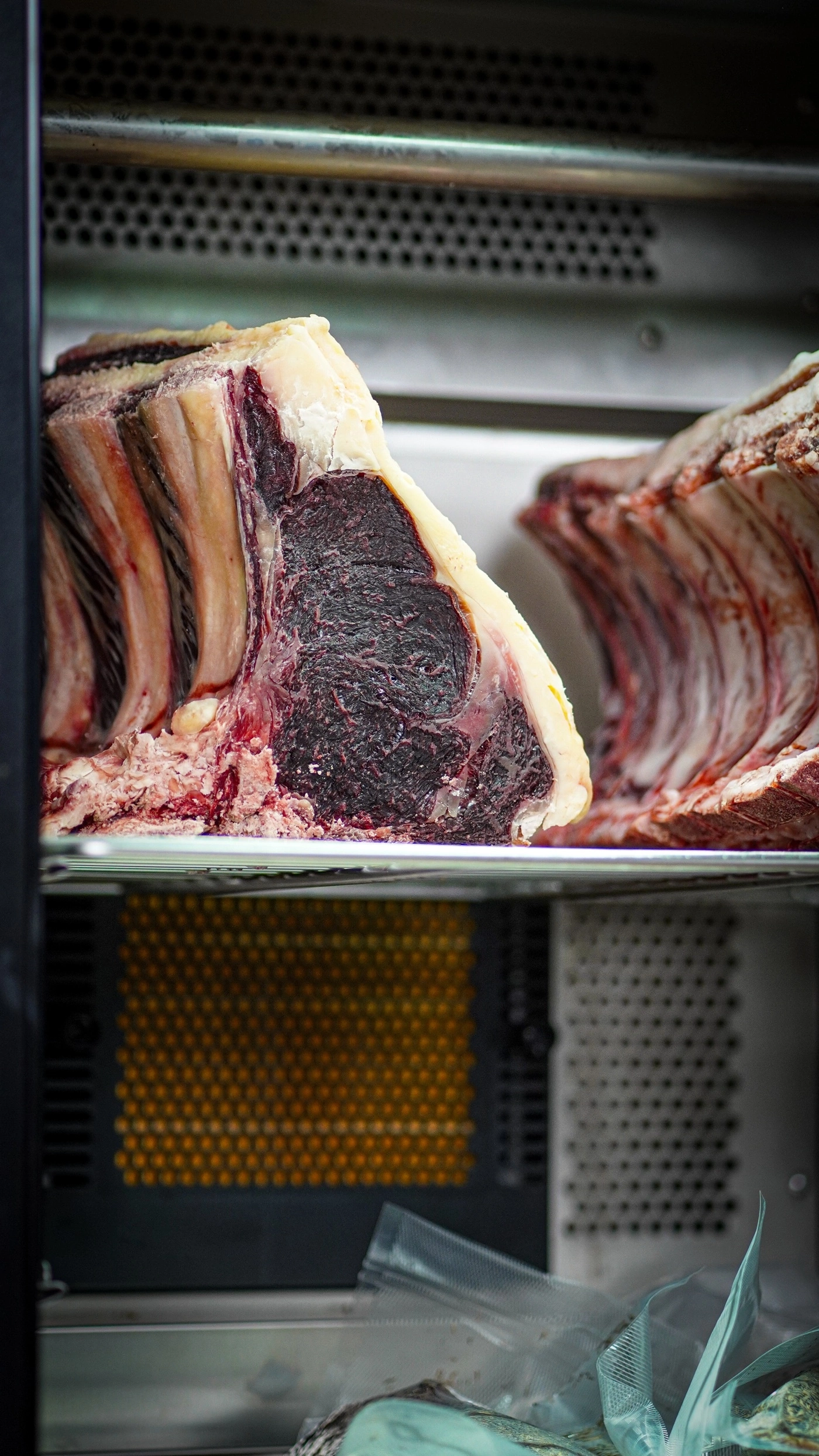 Raw beef steak with bone in a refrigerator.