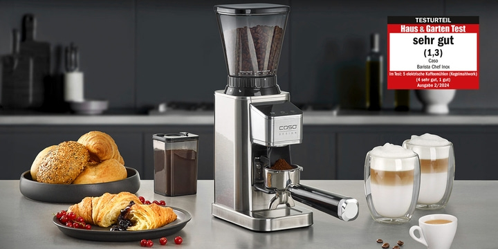Coffee grinder with accessories and 'very good' test result on a table with food.
