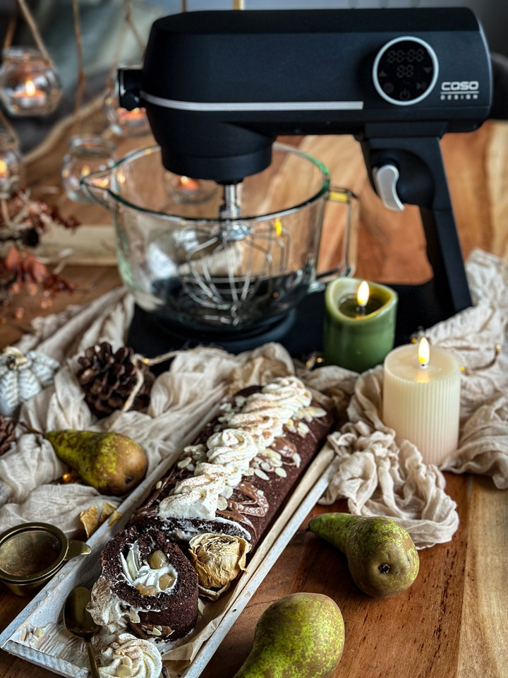 Küchenmaschine, Kuchen, Birnen und Kerzen auf einem Holztisch