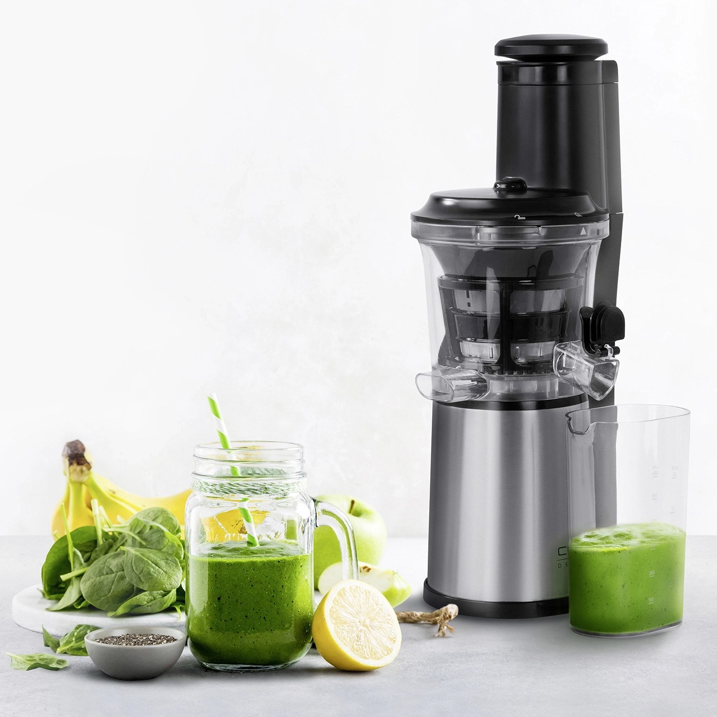 Ein Juicer mit Smoothie, Obst und Gemüse für einen gesunden Lebensstil.