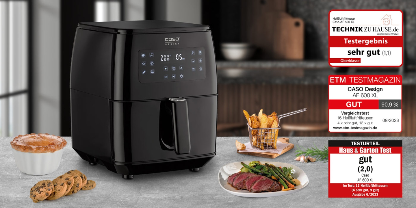 Black air fryer with test results and food on a table, product shot.