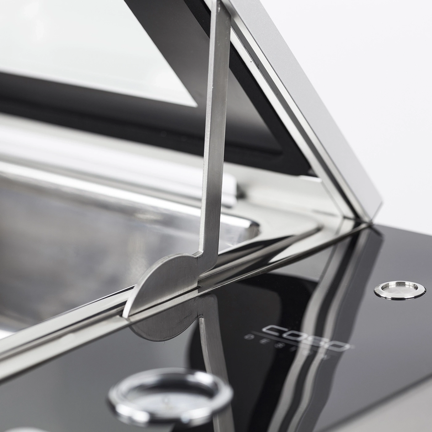Nahaufnahme eines silbernen Geräts mit Glasoberfläche und Metallteilen.