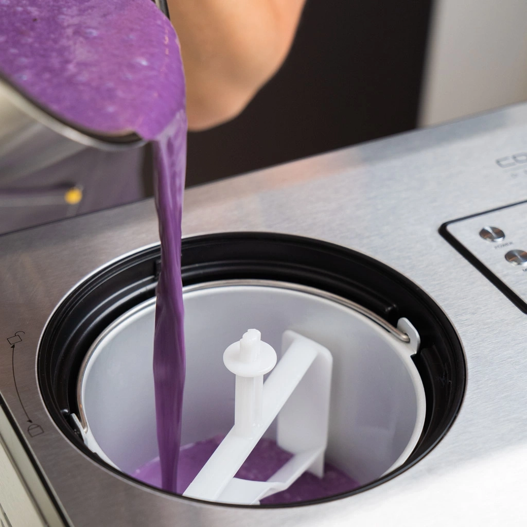 Purple liquid being poured into an ice cream maker, close-up, kitchen, preparation