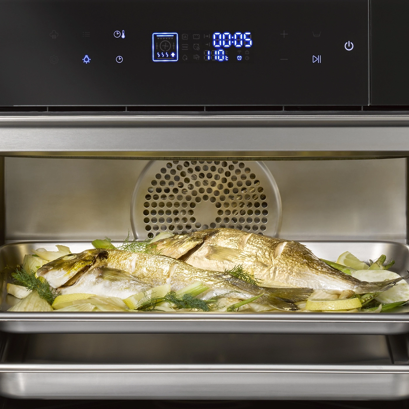 Gebratener Fisch im Ofen mit Gemüse und Zitrone, bereit zum Servieren.