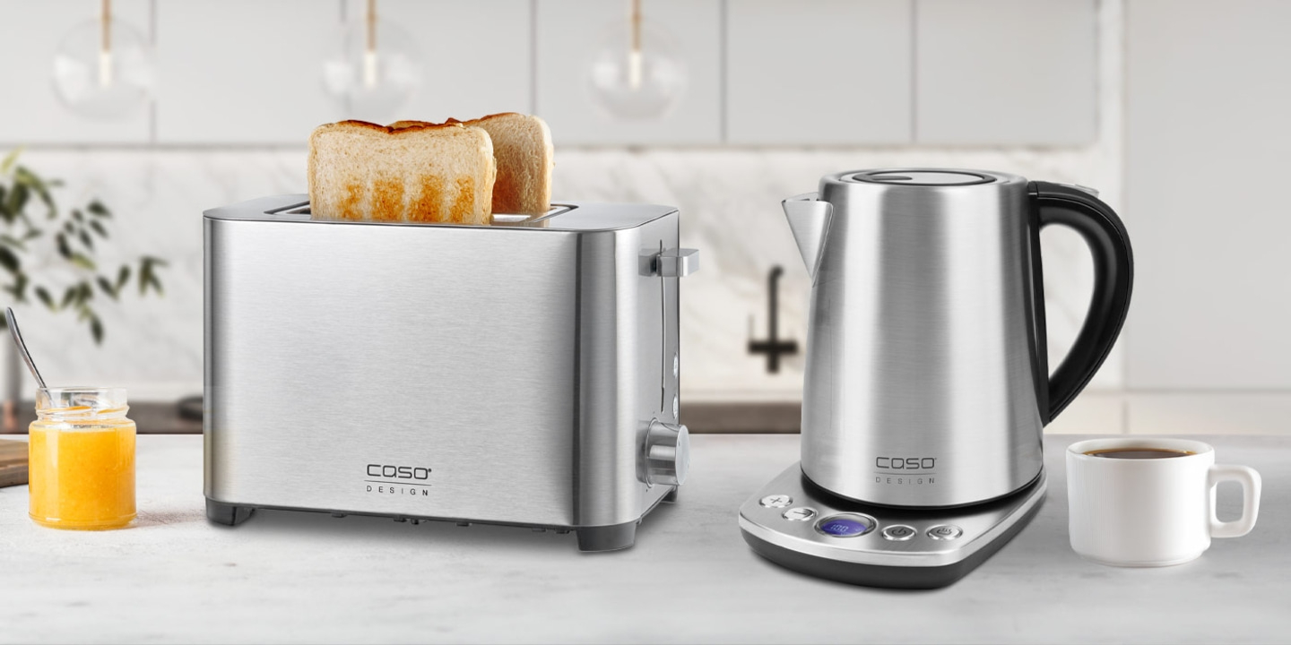 Toaster und Wasserkocher mit Toastbrot und Kaffee auf dem Tisch.