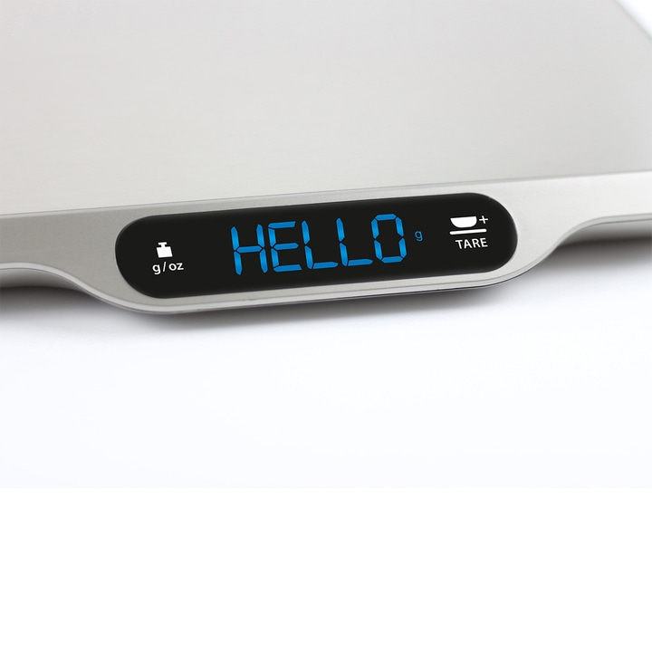 Digital kitchen scale displaying "HELLO" on its screen, close-up shot.