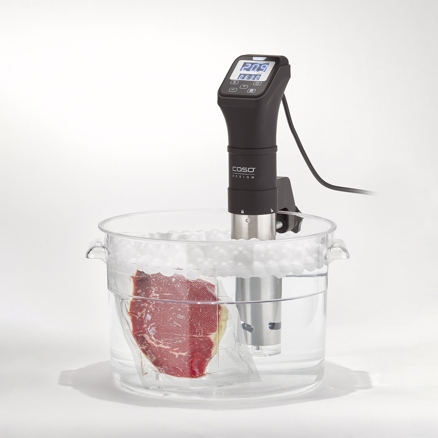 Sous-Vide-Gerät mit Fleisch in einem Wasserbad. Temperaturanzeige und Zeit.