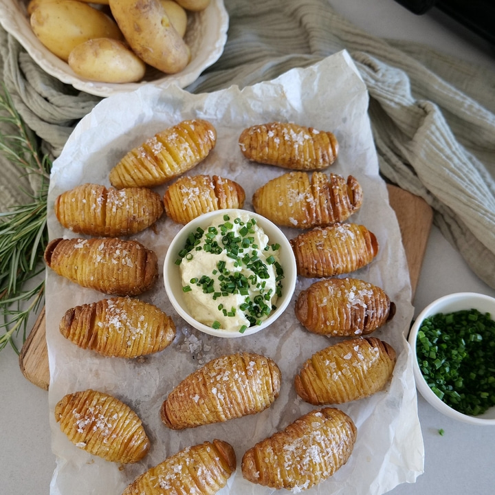 Roasted potatoes with herbs and dip on parchment paper