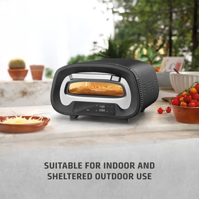 Pizza oven outdoors and indoors, with pizza and vegetables.