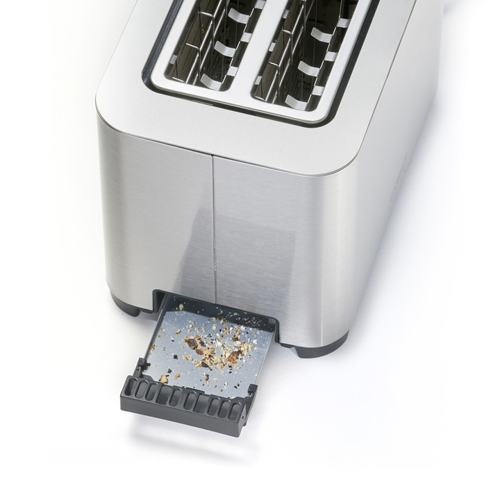 Nahaufnahme eines Toasters mit herausgezogener Krümelschublade und Brotkrümeln