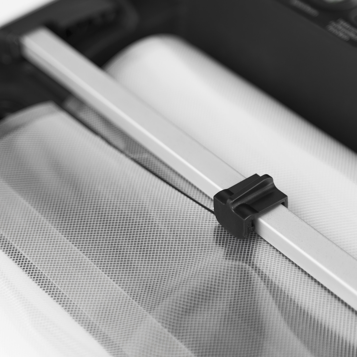 Nahaufnahme von weißem Netzgewebe und einem schwarzen Kunststoffteil