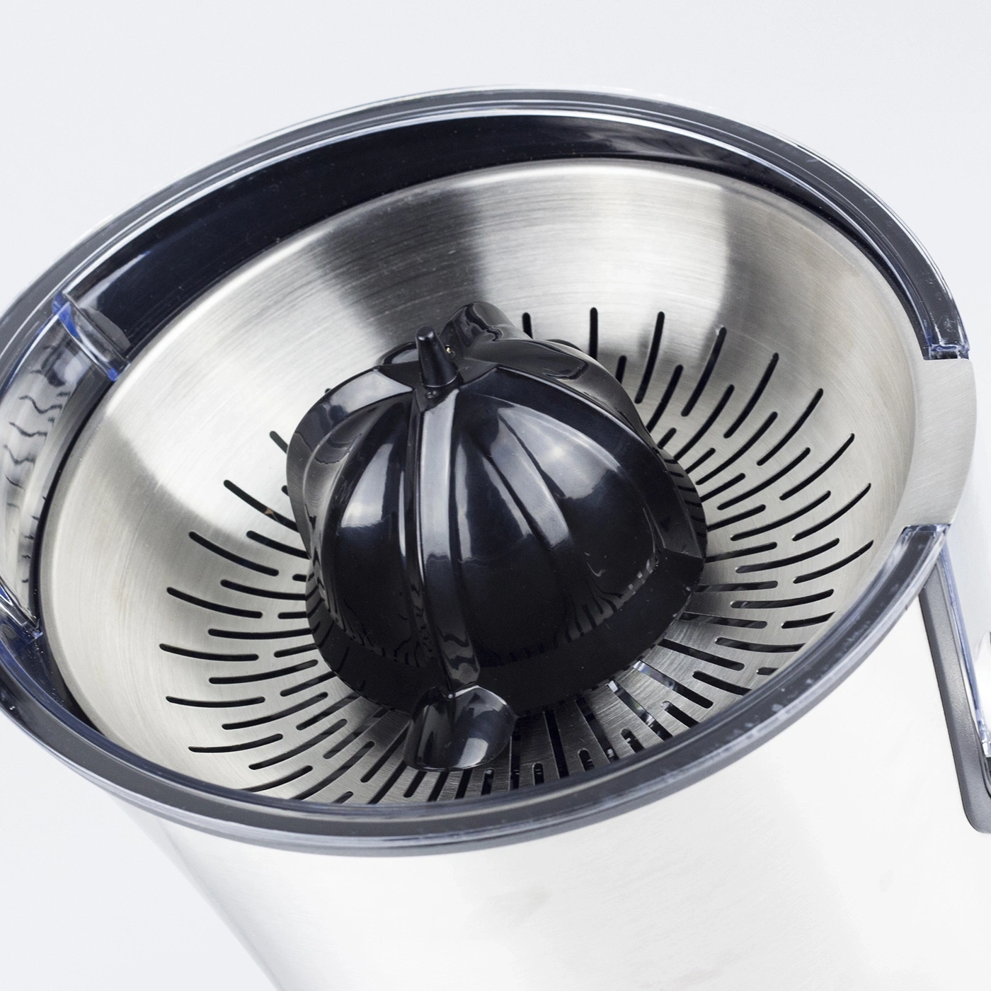 Nahaufnahme eines schwarzen Zitruspressen-Kegels in einer silbernen Schüssel mit Schlitzen