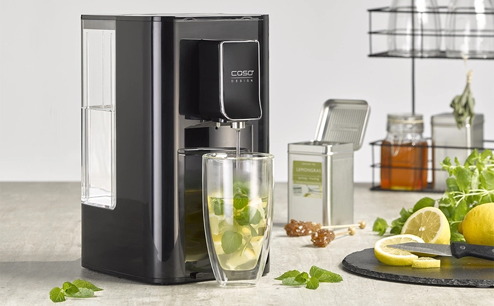 Black tea maker with glass, lemon and mint on the table.