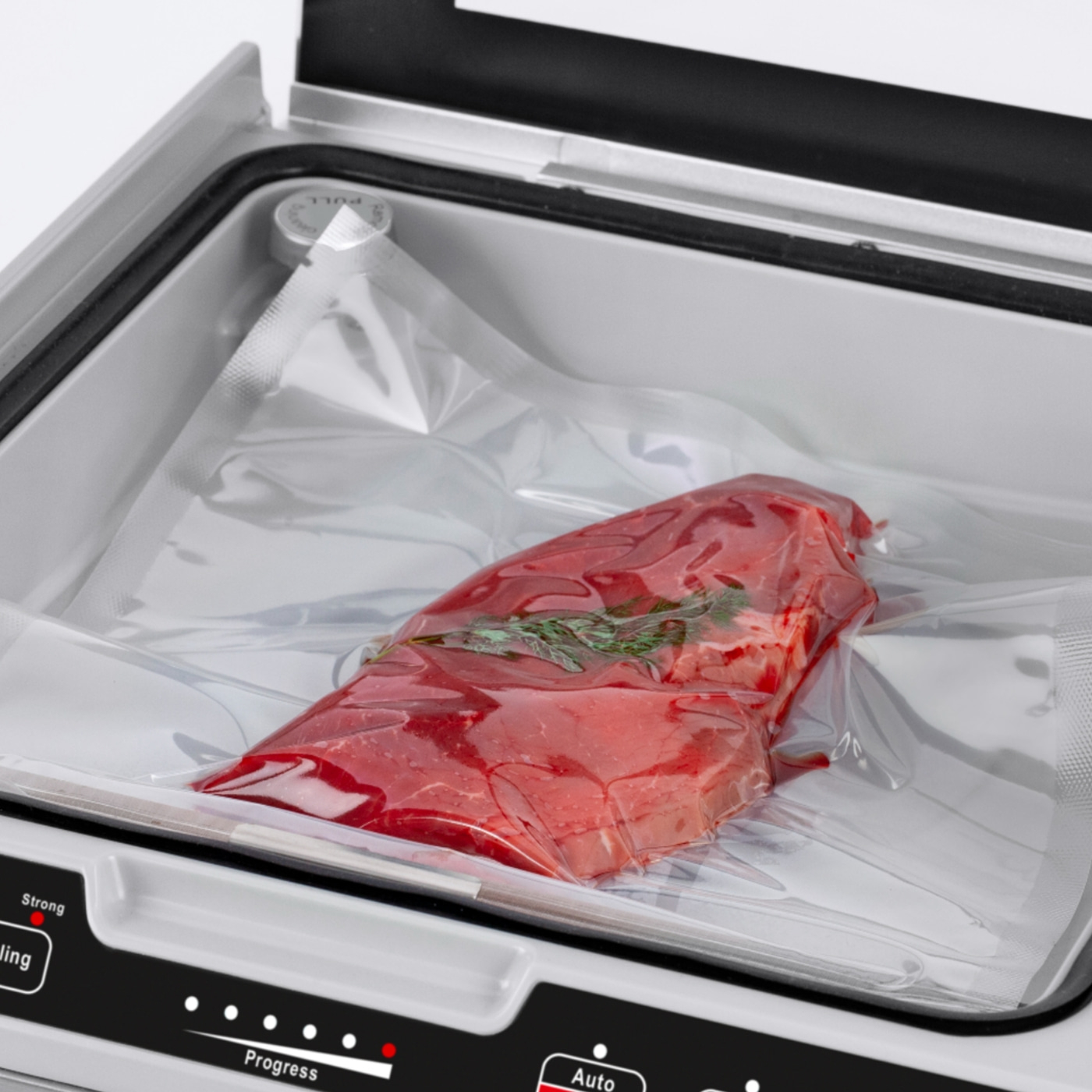 Meat in vacuum sealer, packaged for preservation, red meat, fresh herbs, food storage
