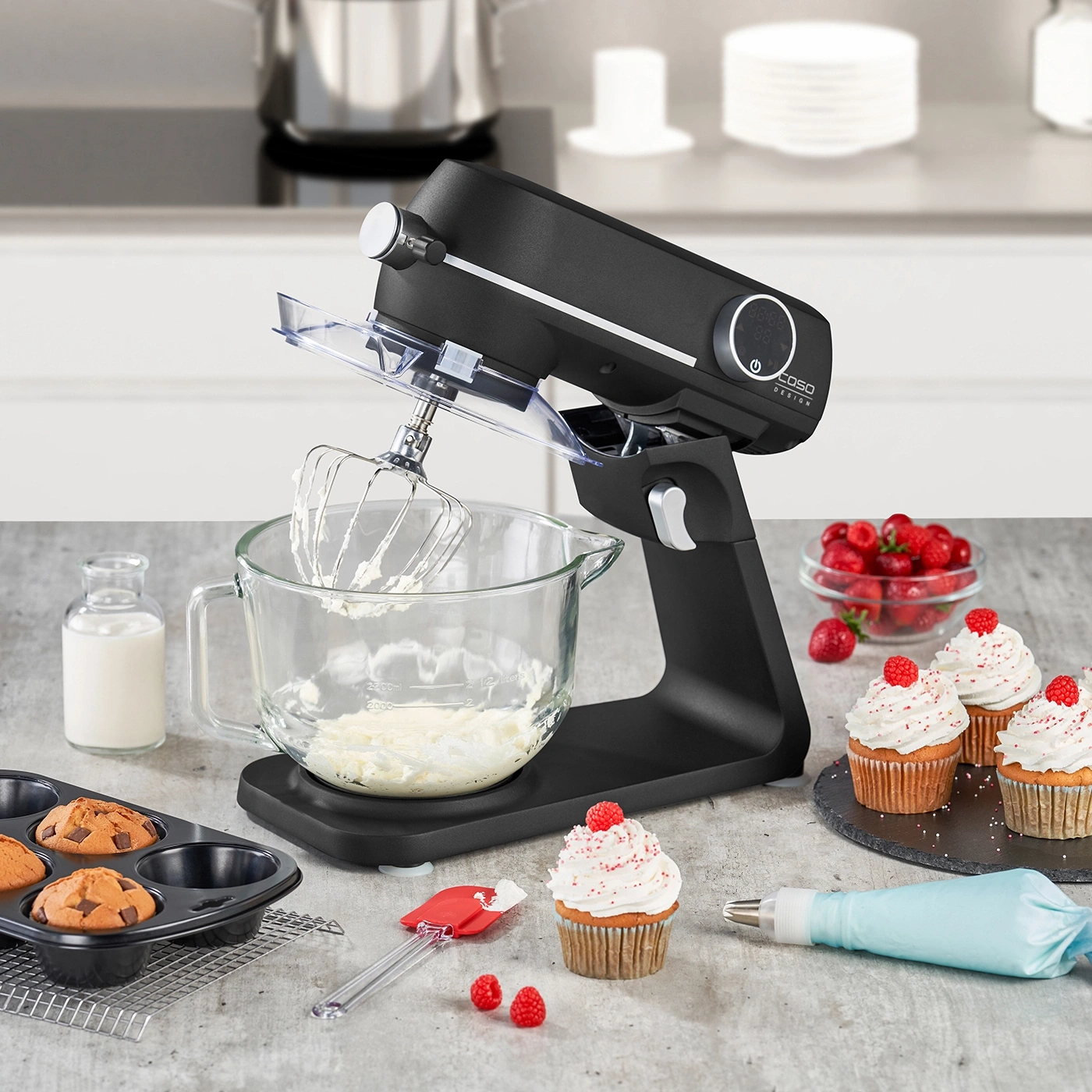 Küchenmaschine mit Cupcakes und Zutaten auf einem Tisch