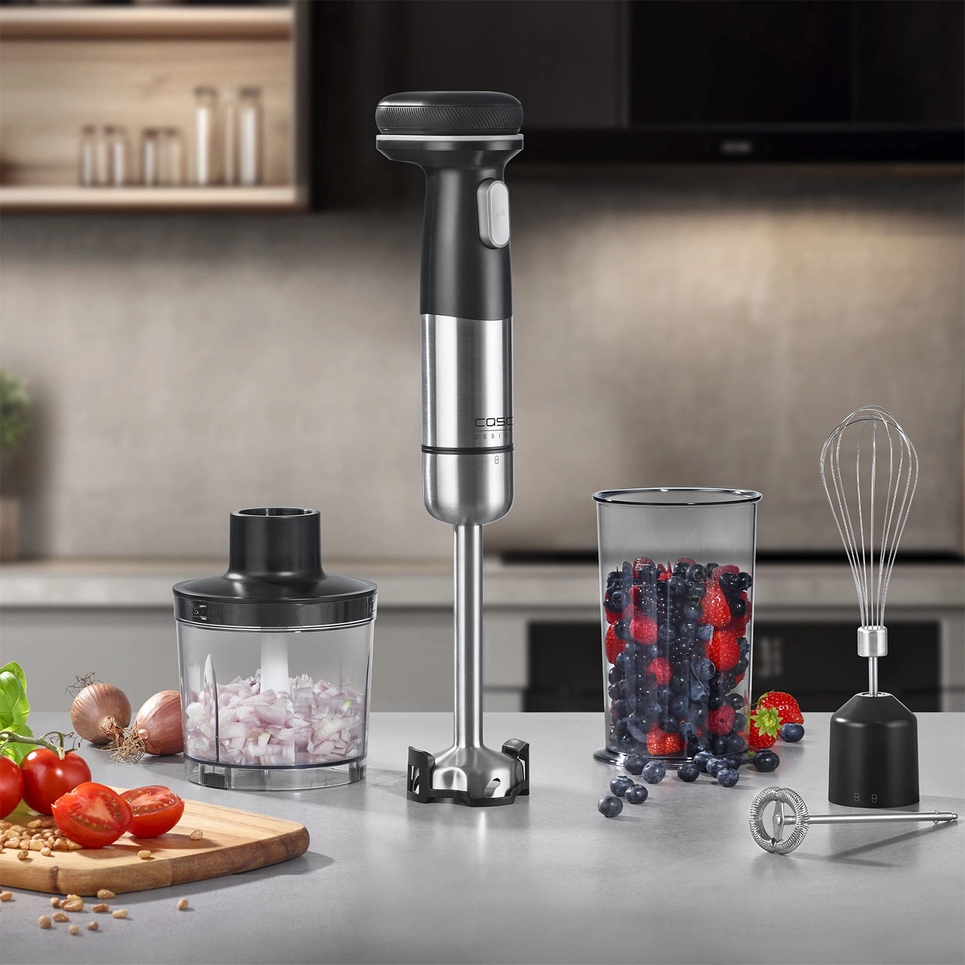 Kitchen appliance set with immersion blender, chopper, beaker, and accessories on a countertop.