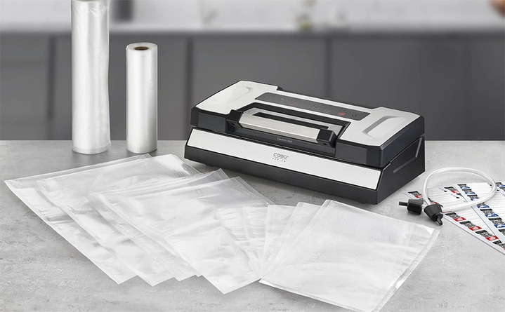 Vacuum sealer with bags and rolls on a work surface