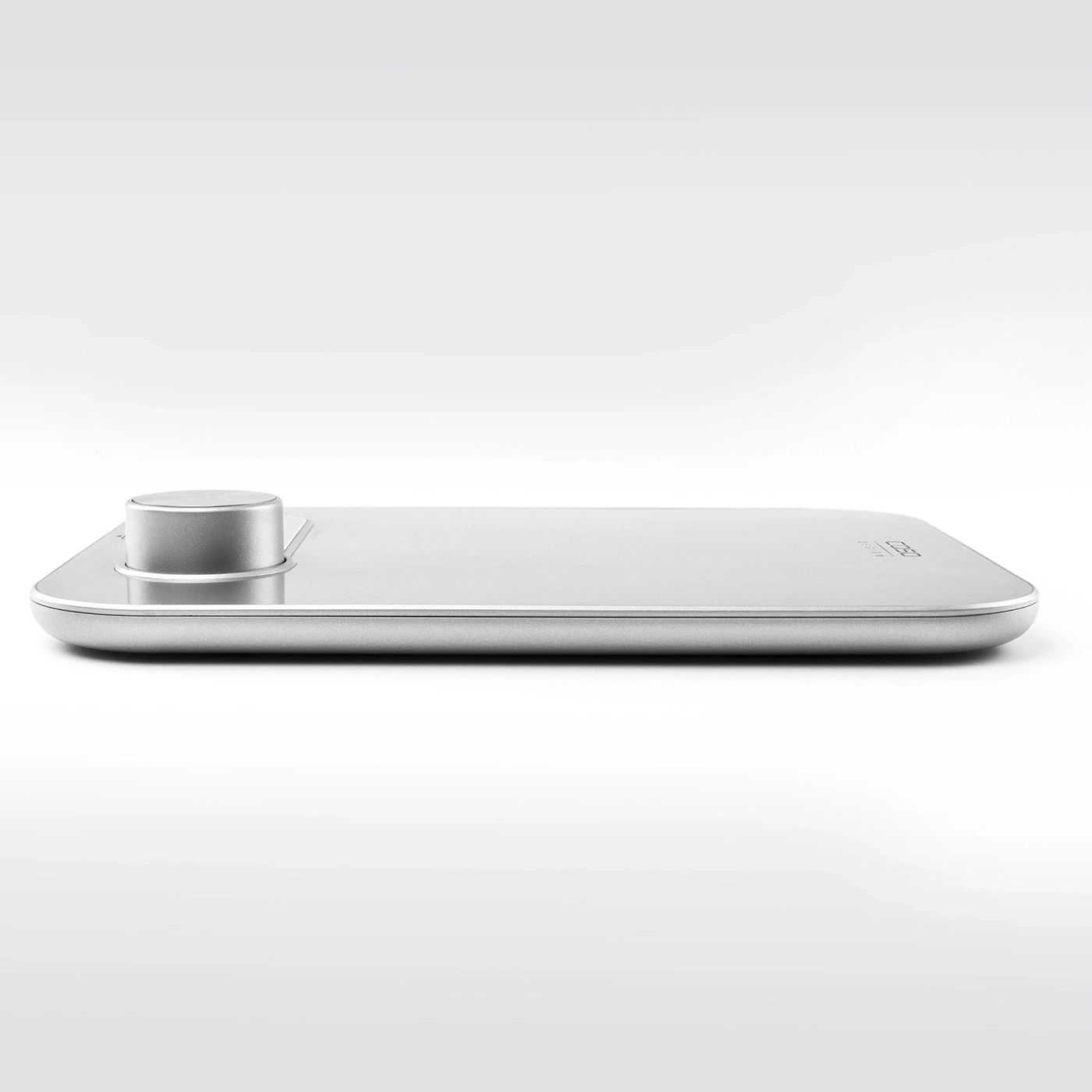 Silver scale with round knob, minimalist design, on a white background, modern and sleek.