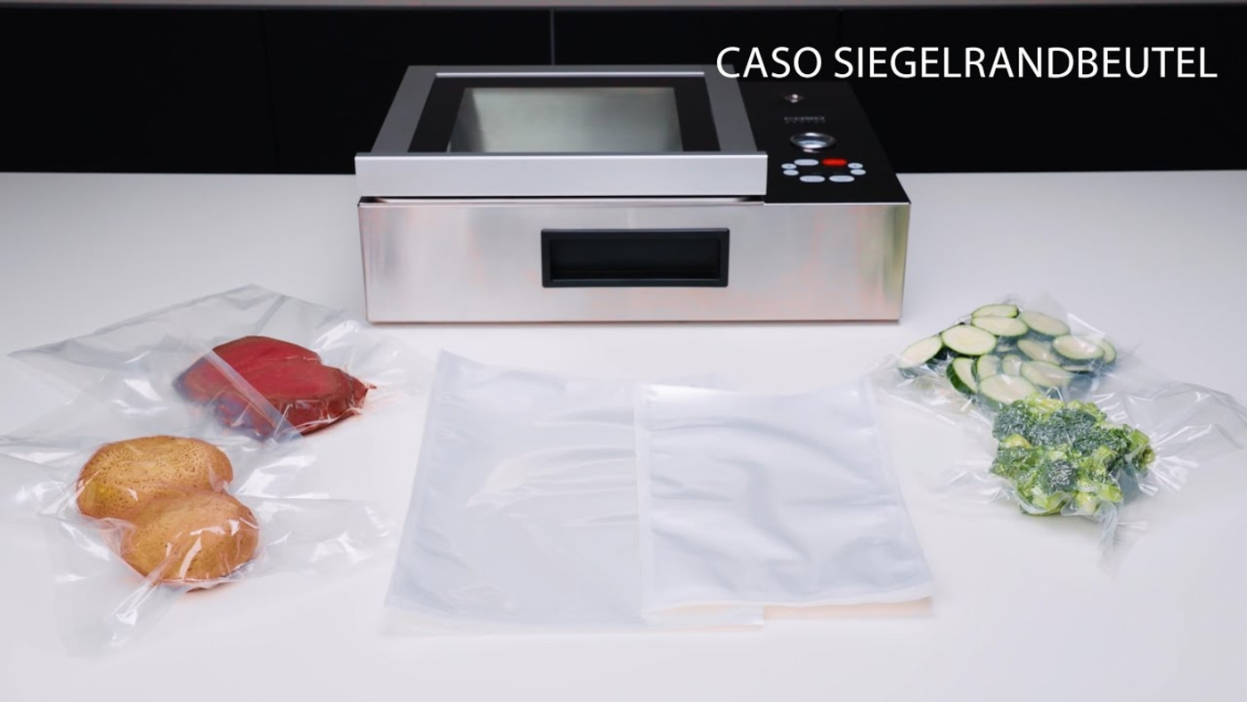 Vacuum sealer with vegetables and meat in bags on a white table
