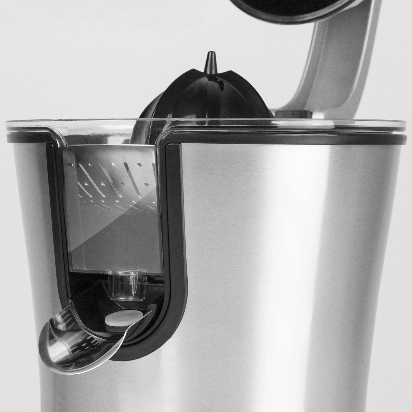 Close-up of a silver juicer with black elements and a transparent container