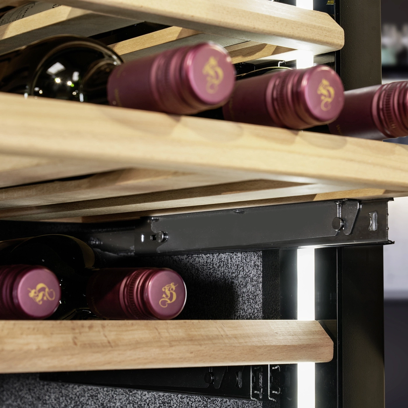 Wine cooler with wooden shelves and wine bottles, close-up, detail shot