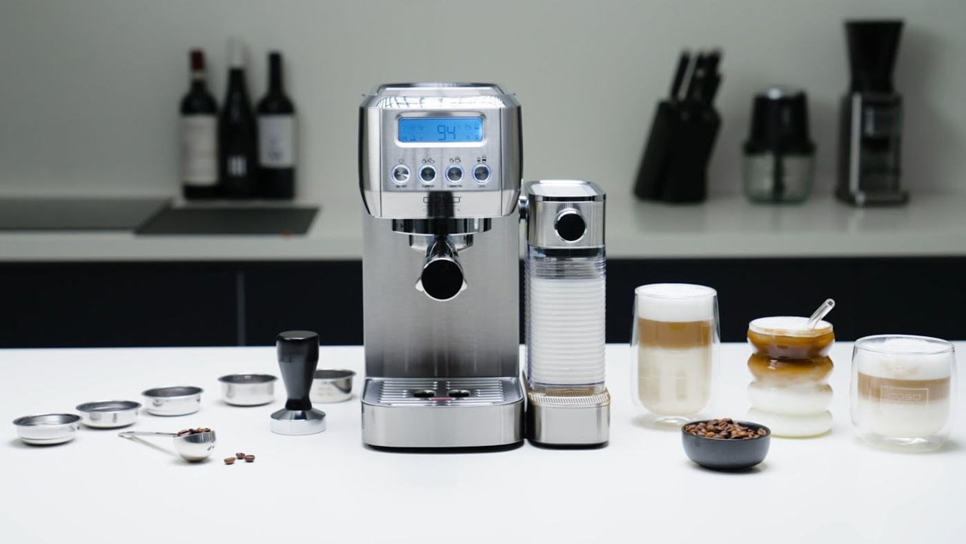 Kaffeemaschine mit Zubehör, Kaffeebohnen und Kaffeegetränken auf weißem Tisch