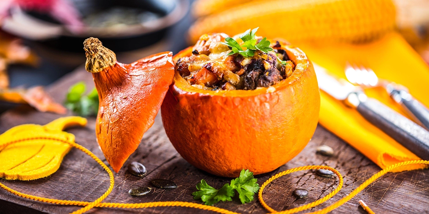 Stuffed pumpkin with herbs and seeds on wood