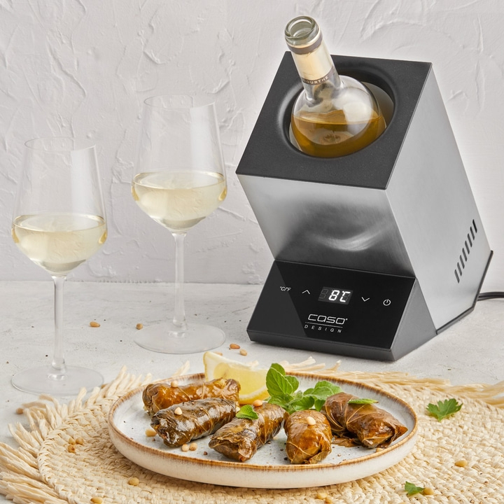 Wine glasses, wine, wine cooler, stuffed grape leaves, lemon, mint, placemat.