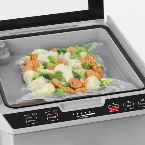 Vacuum sealer with vegetables. Automatic function, progress indicator, and sealing.