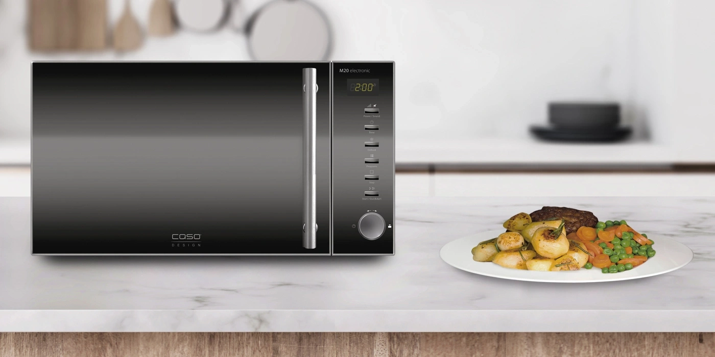 Microwave with food on a plate on a marble surface in a kitchen