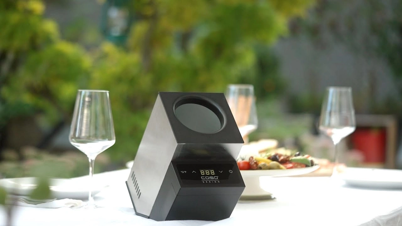 Ein Sous-Vide-Garer steht auf einem Tisch mit Essen und Wein.