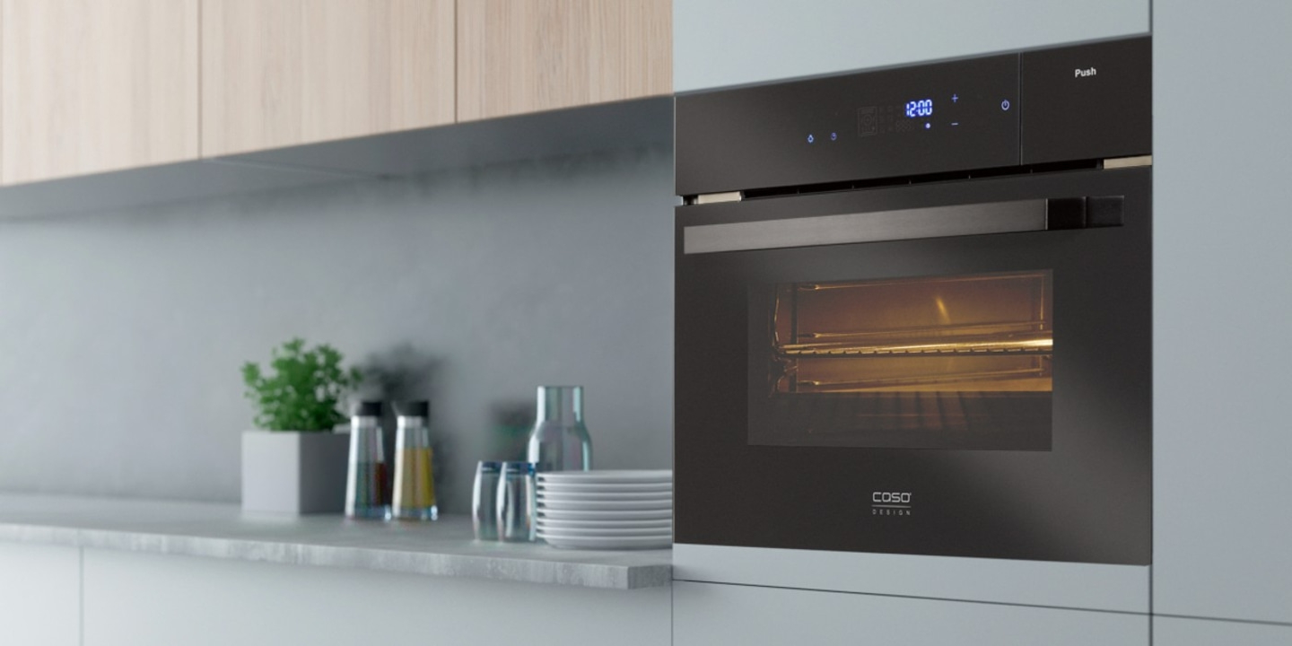 Schwarzer Ofen in einer modernen Küche mit Zubehör und Pflanzen.