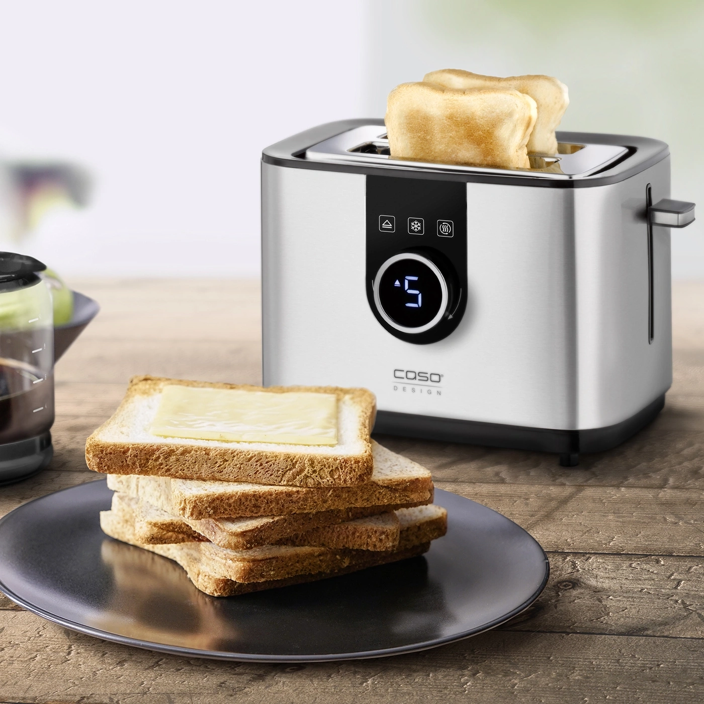 Toaster mit Brot und Käse auf einem Teller auf einem Holztisch