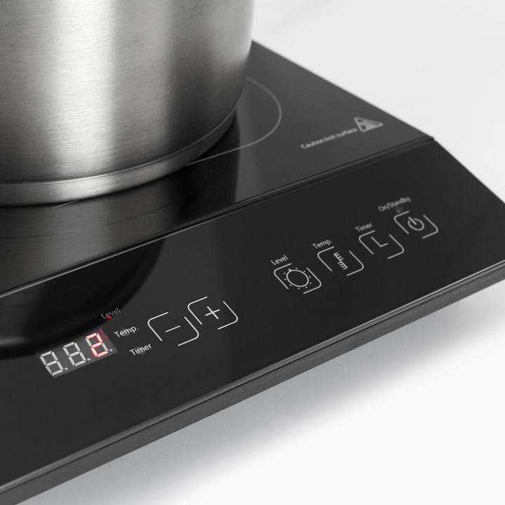 Induction cooktop with pot, control panel with display and buttons, black surface
