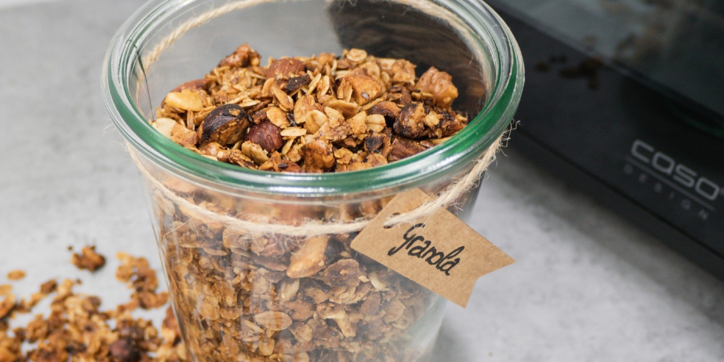A glass of granola with a tag labeled with the word granola. Close up shot.