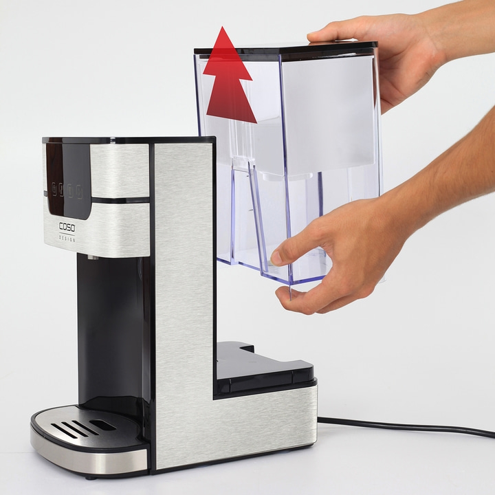Coffee machine with removable water tank being held by a hand, arrow.