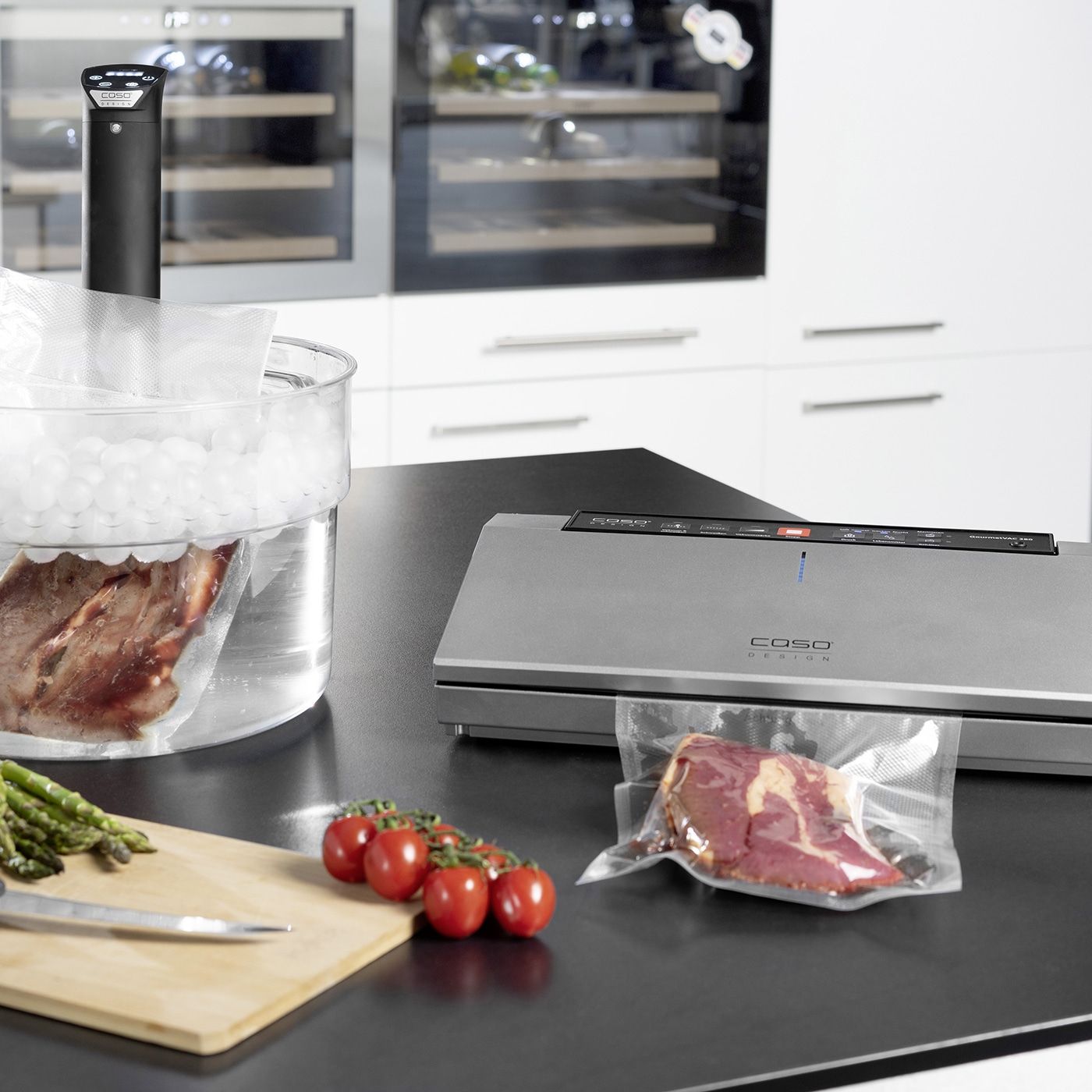 Sous-Vide-Gerät mit Fleisch und Gemüse auf einer Küchenarbeitsplatte